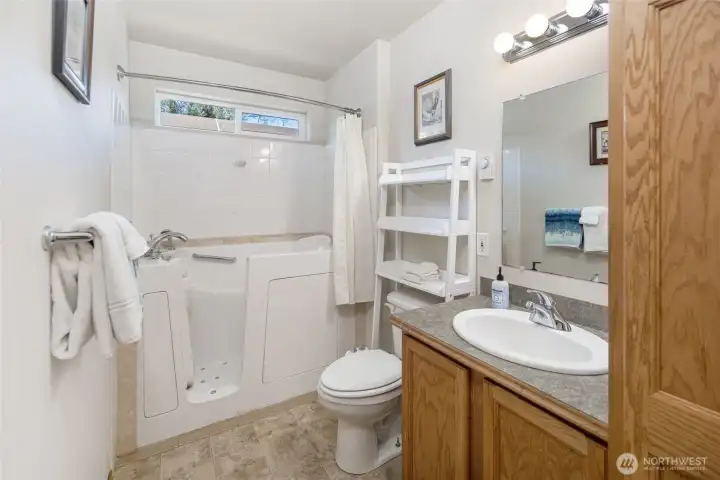 Main level bathroom with walk in tub and shower
