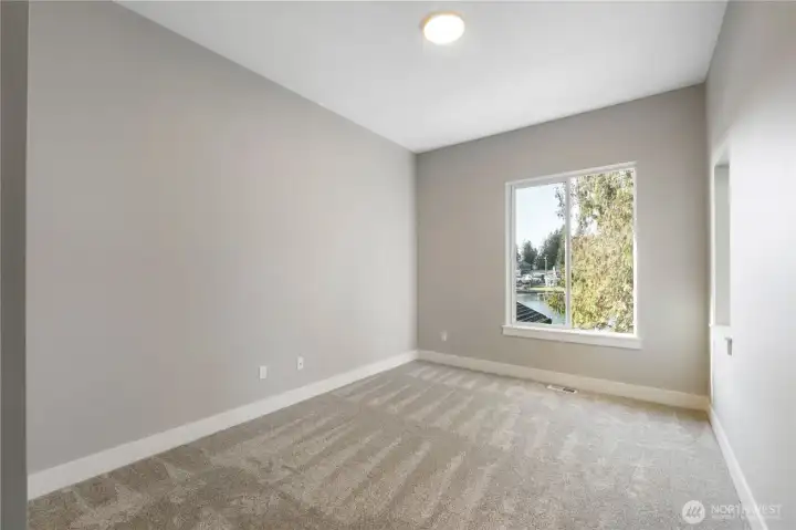 Large windows create a bright 4th bedroom w walk-in closet