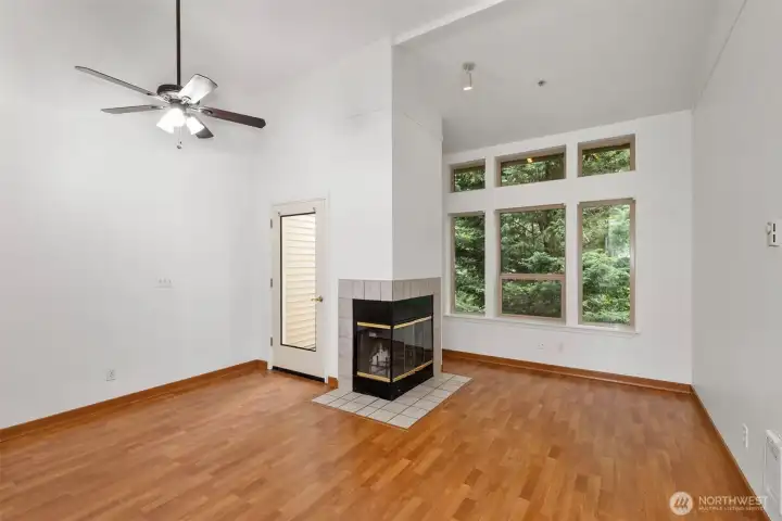 Main living room/ dining with double sided wood burning fireplace and door to back deck.