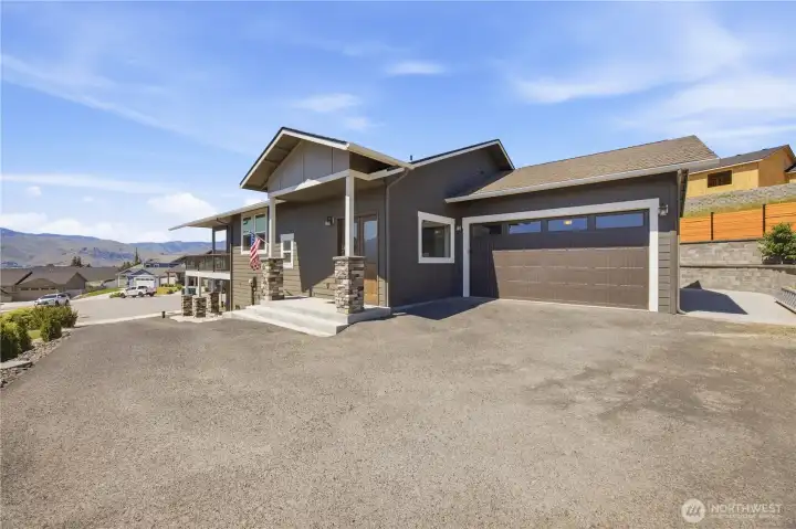 South-facing asphalt driveway with ample parking, easy winter access, and beautifully maintained low-maintenance landscaping.