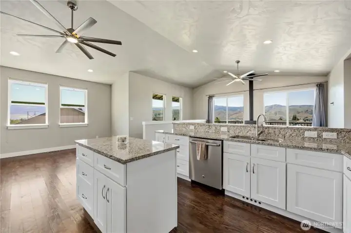 Open-concept kitchen and dining area with real oak hardwood floors, natural light, and seamless access to outdoor entertaining spaces.