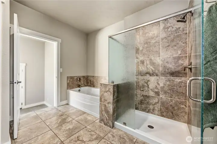 Step-in tile shower with modern finishes and spacious layout in the luxurious primary bathroom suite.