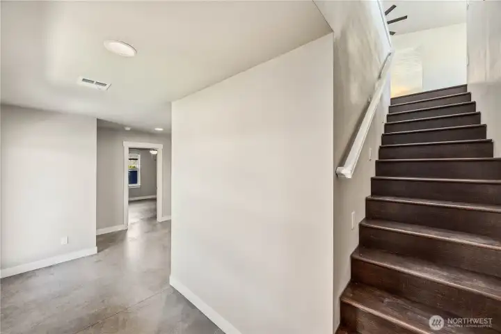 Expansive lower-level living space with concrete floors, tall ceilings, storage, and room for entertaining or multigenerational living.
