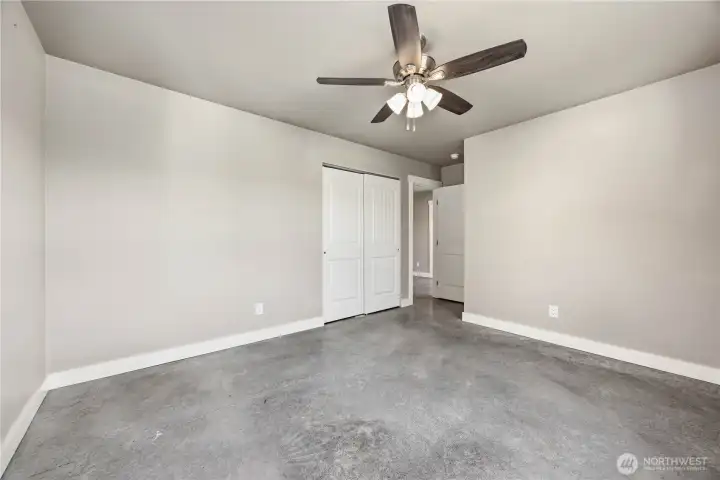 Comfortable guest bedroom with large windows and flexible use for guests, office, or hobbies.
