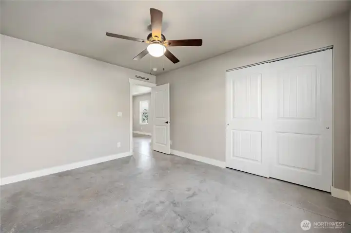 Additional bedroom featuring two windows, overhead lighting, and comfortable lower-level living space.