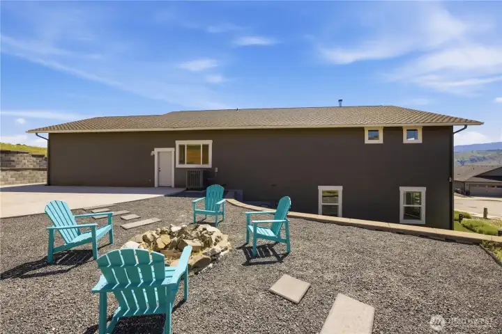 Backyard entertaining area with fire pit, artificial turf, retaining walls, and incredible sunset views.