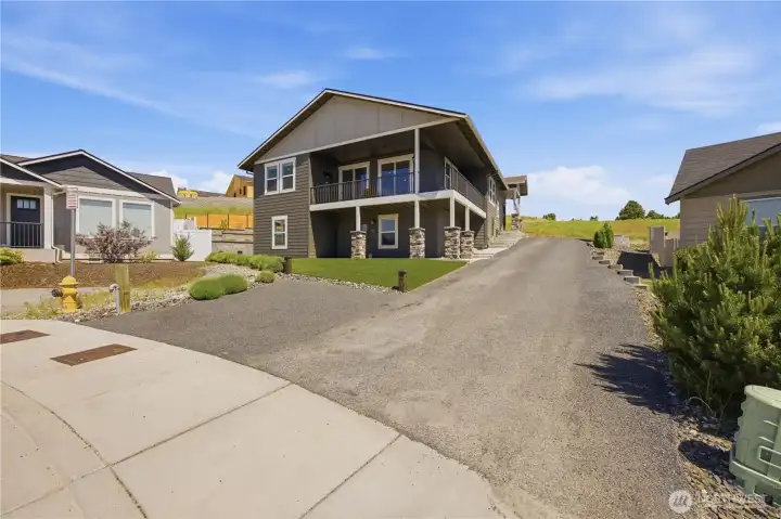 Beautiful hillside home tucked into a quiet cul-de-sac featuring Hardie Plank siding, fresh exterior paint, low-maintenance landscaping, and stunning curb appeal with panoramic valley views.