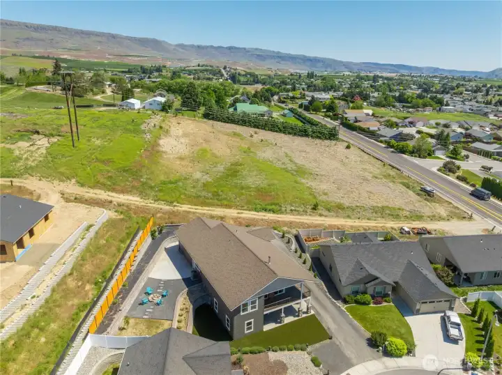 Stunning aerial perspective showcasing the home’s elevated hillside setting, wraparound Trex decking, beautifully designed outdoor spaces, and sweeping 180-degree valley views.