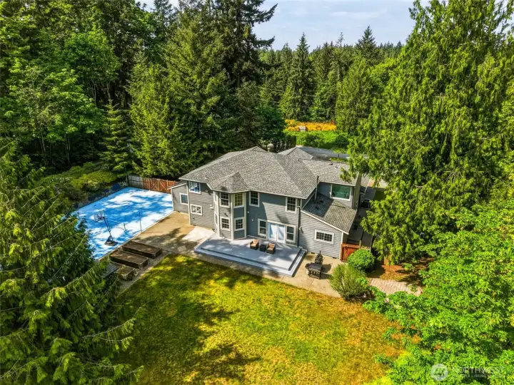 Aerial view showcasing partial 1.14-acre property, shop, and private setting surrounded by nature.