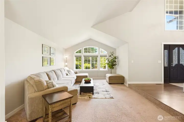 Spacious family room with vaulted ceilings, large windows, and open layout designed for comfortable everyday living.