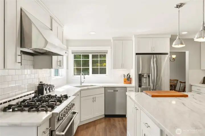 Remodeled kitchen with granite countertops, tile backsplash, stainless steel appliances, and functional layout.