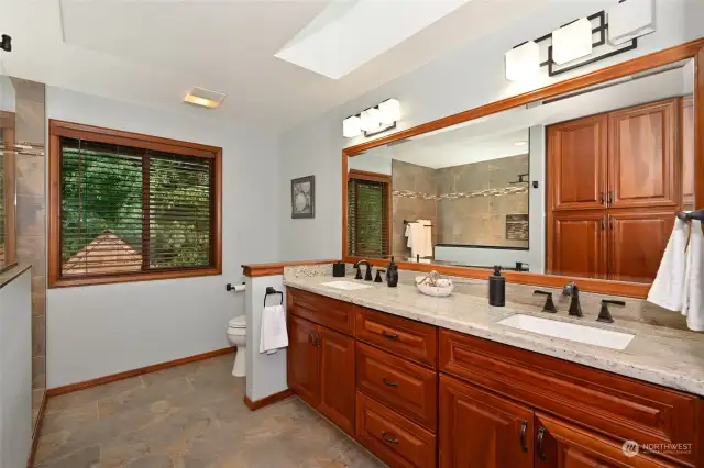 Heated tile flooring, dual vanity sinks, a granite countertop, a skylight, and a linen closet.