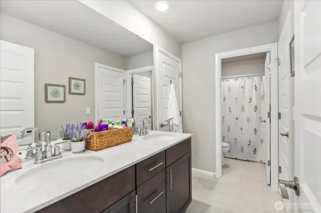 Roomy upper level Jack-N-Jill bath with double vanities and separate toilet/shower room.