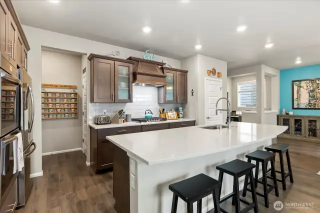 LOOK at that wonderful quartz kitchen island.  A great way to catch up at the end of the day! Kitchen also features a nice pantry.  Just off the kitchen is a coffee alcove and access to the lower level guest suite.