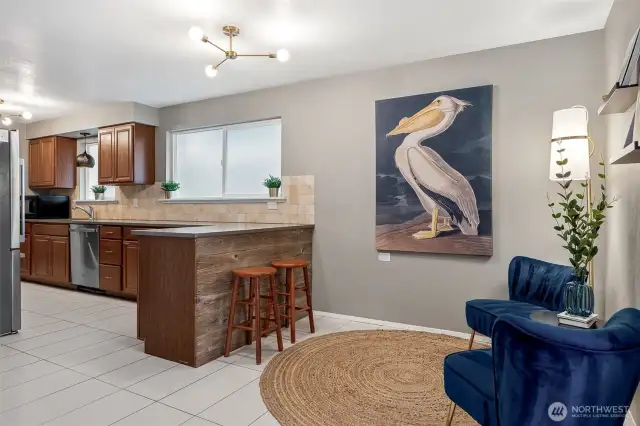 Style Meets Versatility. This dining-slash-lounging area with a retro-cool Sputnik light and durable tile floors flows seamlessly into the kitchen. The peninsula’s bar seating makes it perfect for snacks, chats, and everything in between.