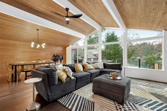 Let’s talk about those vaulted ceilings with white crossbeams—total showstoppers. A light wood panel ceiling and wood laminate floors keep things feeling airy, while a huge wall of windows brings Long Lake right into your family room. Oh, and that Sputnik chandelier? Total perfection.