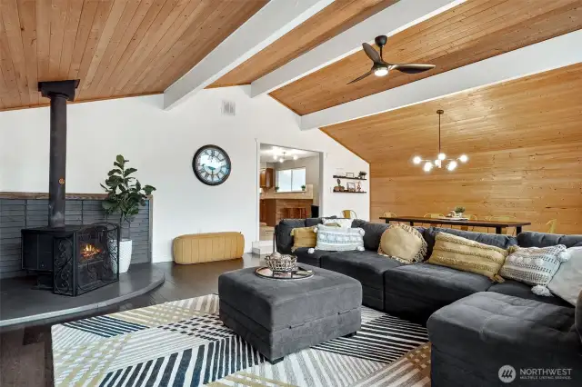 Vaulted ceilings, a stunning waterfall effect down the dining wall, and a cozy wood stove corner... it’s like the room is telling a story. And the dining area? Perfect for both casual meals and big gatherings.