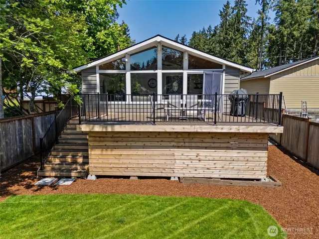 This view says it all: a spacious deck for cooking, dining, and lounging, with a wide staircase leading down to the lush backyard. The mid-century peaked roofline adds character, while the wall of windows in the family room brings the outside in. Plus, the partial fencing provides just enough privacy without losing that open feel.