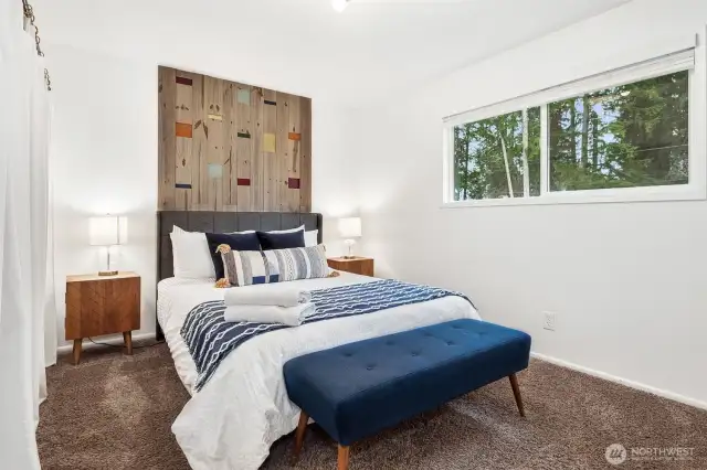 This primary suite is the epitome of calm. Mushroom-tone carpet, a bold accent wall, and tree views bring a touch of nature in without compromising on style. It's a little slice of peace in your own home.