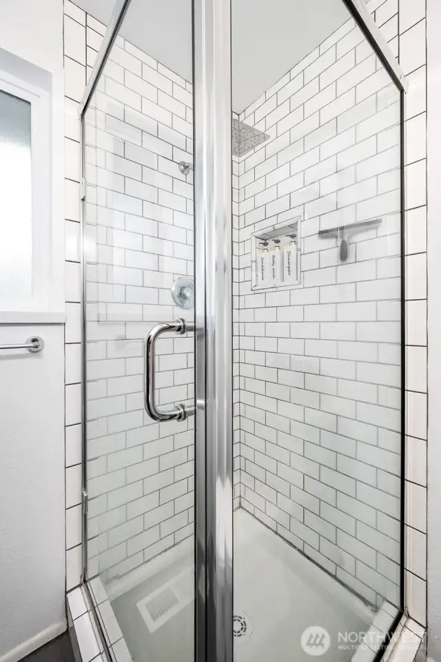 This primary suite bathroom keeps it simple yet sleek with dark tile floors, crisp white subway tile, and a glass shower. The single basin sink vanity adds a streamlined touch that makes every morning feel fresh.