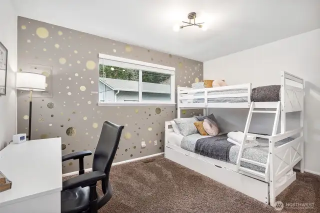 The updated Sputnik light fixture in the 2nd bedroom adds a touch of flair, while the accent wall and rich mushroom carpet bring warmth and character to this stylish space. Clean white walls keep everything fresh and airy.