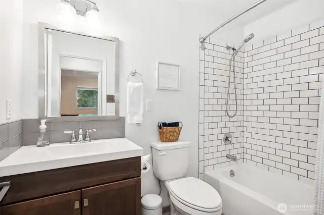 We’ve got subway tile, contrasting grout, and a showerhead that works both ways—what more do you need? The glass backsplash adds a pop of polish to the vanity, so this bathroom is both functional and fabulous.