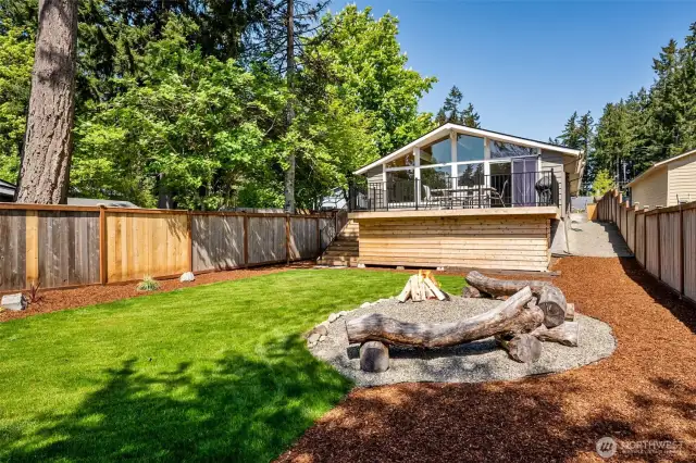Your Backyard, Your Escape. Imagine this: a lush green lawn, perfectly level for all your outdoor activities, with a cozy firepit area that’s practically begging for marshmallow roasting. Log seating adds rustic charm, and the lake in the distance gives it that tranquil, “nature’s right outside” vibe. Lots of privacy with the new fence panels to give you lots of privacy for your chill moments.