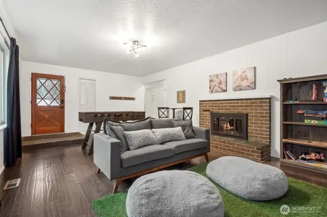 From the character-rich entry door to the classic brick fireplace, this living room is all about blending vintage charm with everyday practicality. Bonus points for the louvered coat closet that keeps clutter out of sight!
