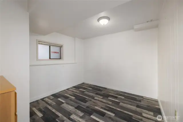 Corner bedroom with hanging storage chest and closet.