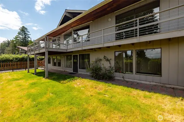 Rear of the home featuring a slider from the primary, access from the kitchen and lower level of home.
