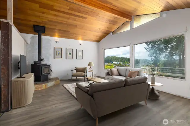 Spacious living room with wood planked vaulted ceiling, wood burning stove, views of the channel/canal, Rainbow bridge.