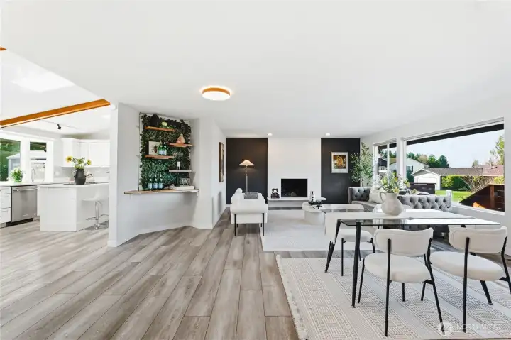 Large living and dining space filled with natural light. Custom automatic blinds stay with the home.