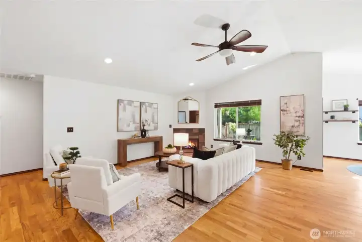Light-filled living space with vaulted ceilings and a ceiling fan that enhances comfort and keeps air moving.