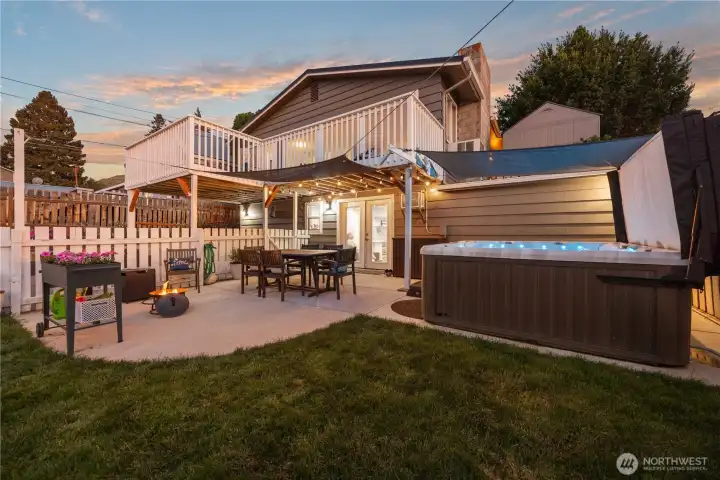 Exterior view of home with outdoor living area with dining area, fire pit and private hot tub. Exterior view of home with outdoor living area with dining area, fire pit and private hot tub.