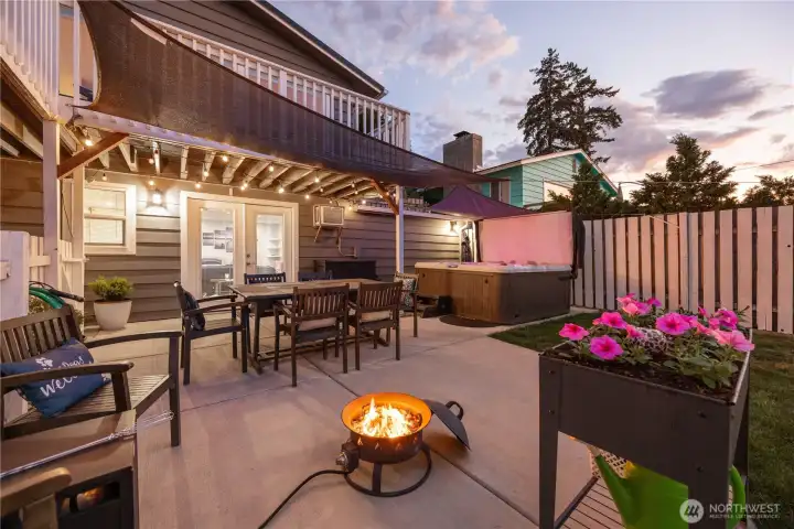 Twilight view of outdoor living space with dining area, private hot tub and fire pit. Twilight view of outdoor living space with dining area, private hot tub and fire pit.
