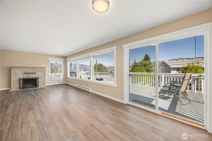 Main level living and dining room with fireplace and glass sliding doors leading to the lake view deck. Main level living and dining room with fireplace and glass sliding doors leading to the lake view deck.