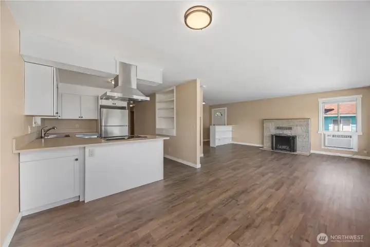View of main level kitchen, dining and living room with fireplace and glass sliding doors leading to the lake view deck. View of main level kitchen, dining and living room with fireplace and glass sliding doors leading to the lake view deck.