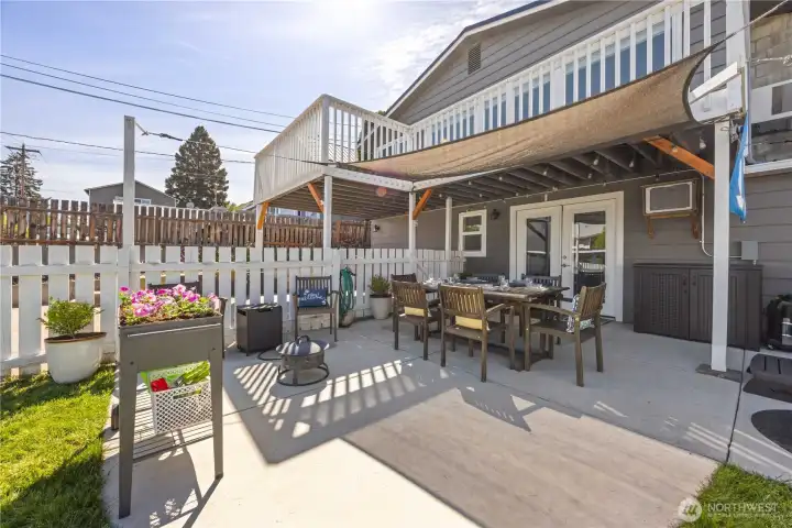 View of outdoor living area with dining and lounge area, private hot tub and fire pit. View of outdoor living area with dining and lounge area, private hot tub and fire pit.