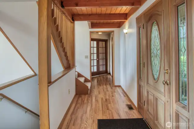Main floor corridor leads to primary suite, stairs up lead to loft.
