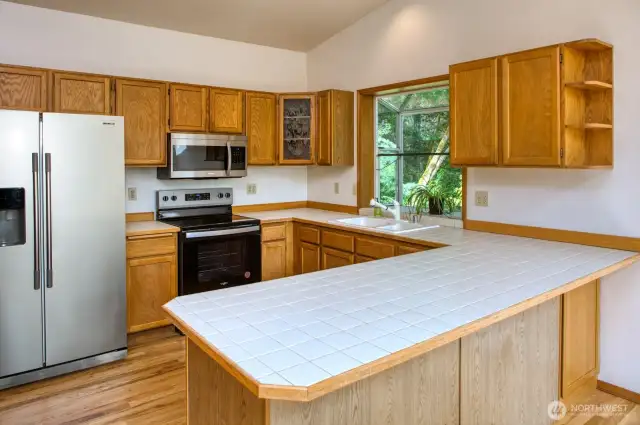 Kitchen offers hardwood cabinets, tile counters and newer appliances.