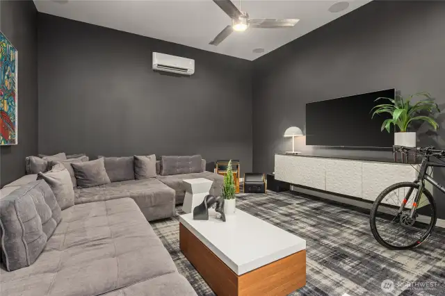 Media or exercise room with surround sound system and a ductless heat pump for heating and cooling