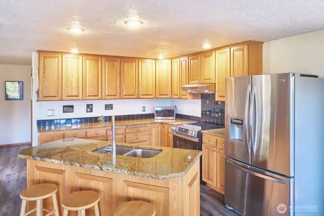 Oak cabinets, new stove and granite slab island with sink.