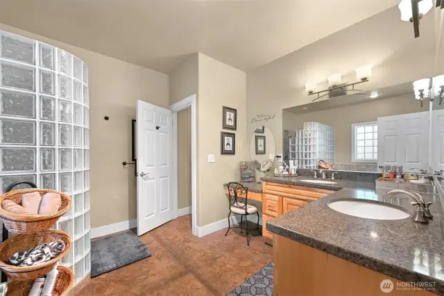 The primary bathroom suite has a spacious double sink vanity. The vanity wraps the corner of the bathroom making it easy to have two people in the same space.