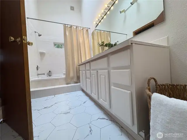 Newly installed marble tile flooring brings a bright, clean finish to the space—elevating the bathroom with timeless style and easy-care elegance. There’s even room for a laundry basket or additional storage.