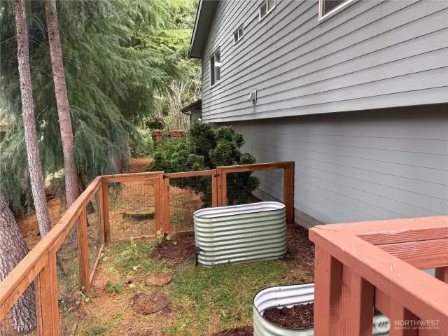 Just beyond the deck, discover one final garden nook with additional raised beds and a secondary gate—offering even more space to grow and a flexible layout for outdoor living.