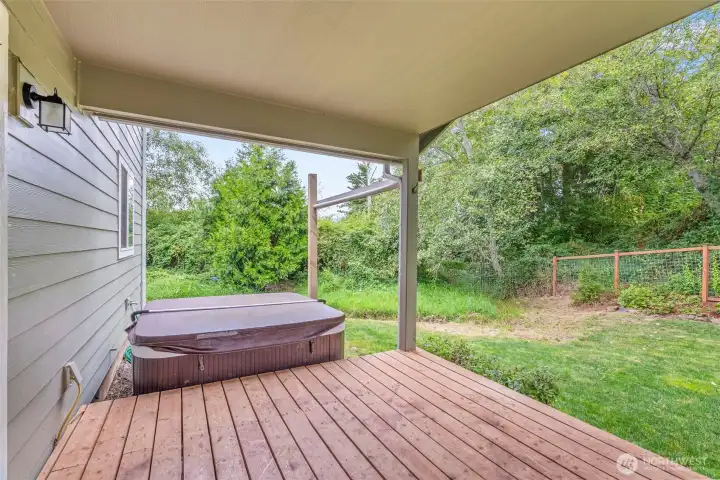 Covered cedar deck, partially fenced yard.  Hot tub is excluded.