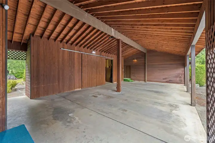 Huge carport with door that leads into the shop