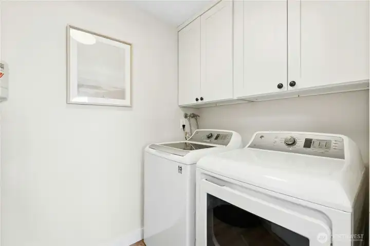 Dedicated laundry room with built-in storage shelves. Washer and dryer included.
