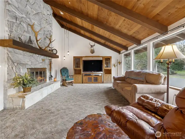 The living room boasts a gorgeous stone fireplace, competing with the brand new picture windows for center focus in this cozy but spacious  room.