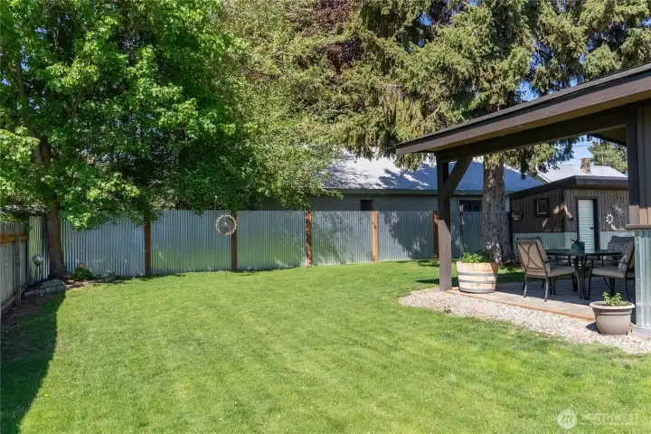 The sunny fenced yard beckons for a green thumb!